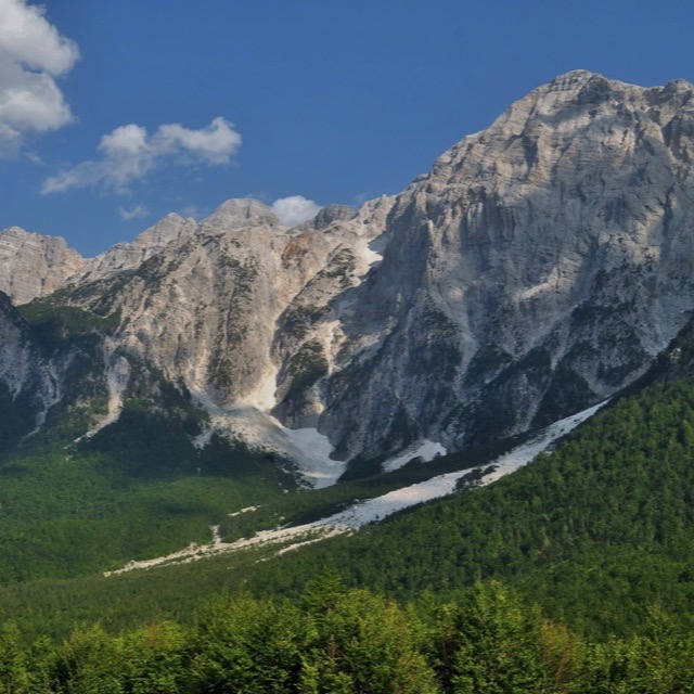 Limestone peaks of the Accursed Mountains above green forest